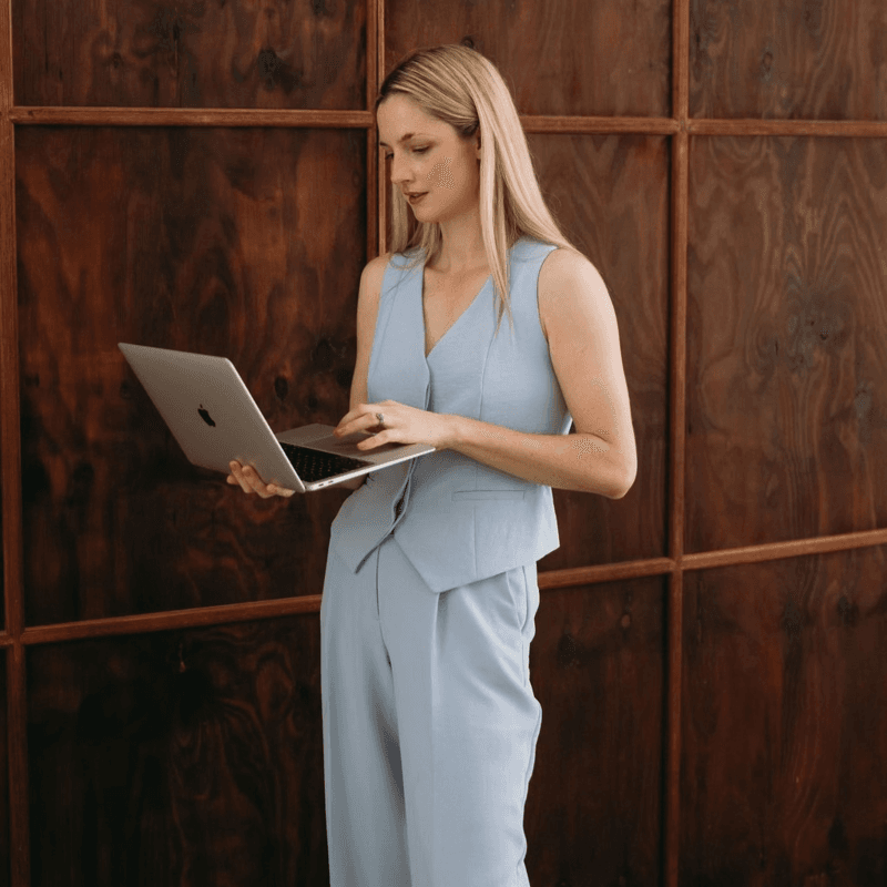 Chloe, founder of Socially Acceptable, holding a laptop